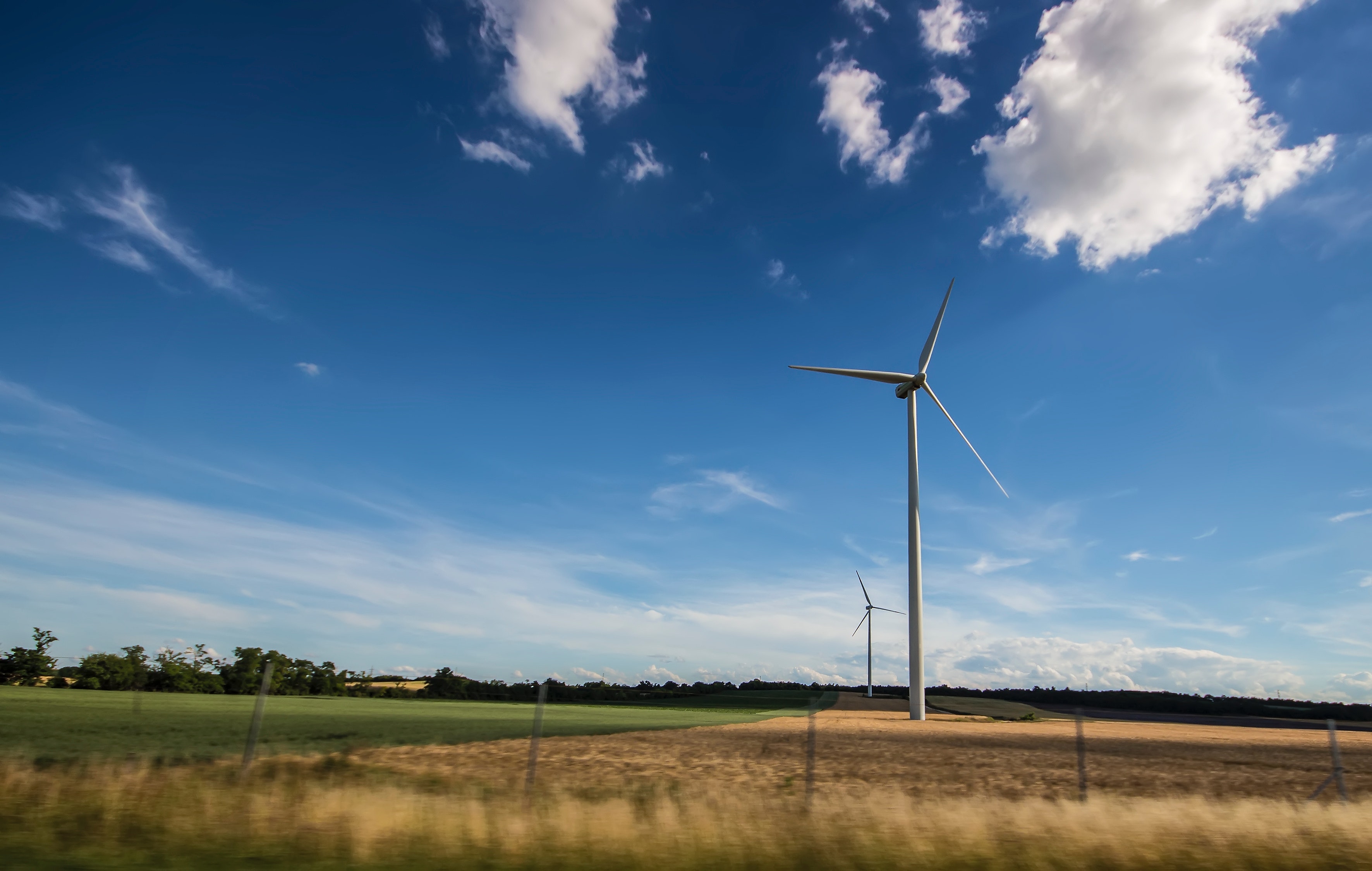 Windrad auf einem Feld unter blauem Himmel