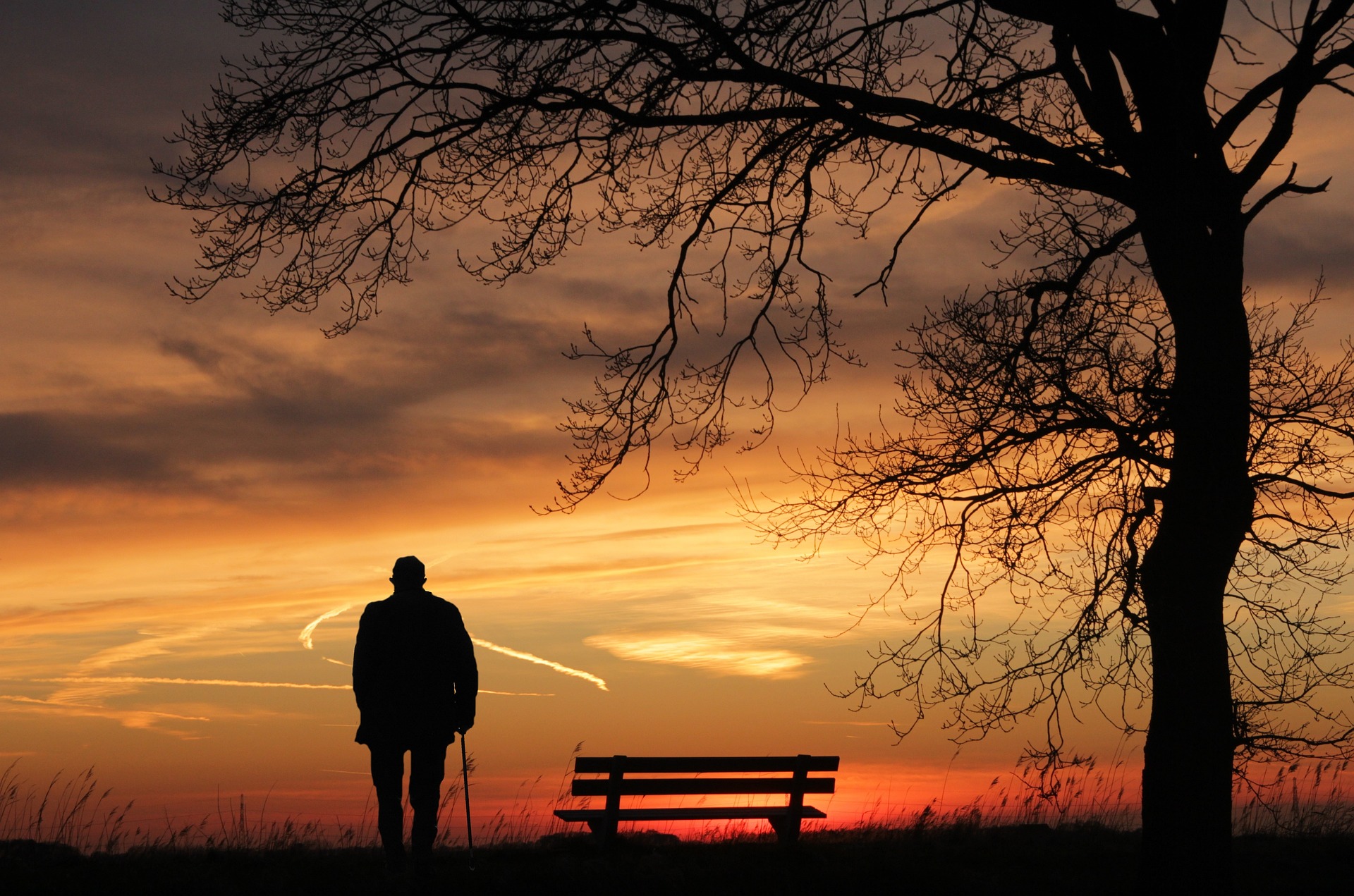 Ein älterer Mann beobachtet einen schönen Sonnenuntergang.