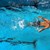 Schwimmender Mann mit Badekappe im Wasser